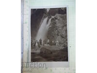 An old photo of a group of young people in front of the waterfall