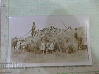 Old photo of a man on the straw with many children in a cart