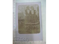 Old photo of two women in costumes in front of a cart