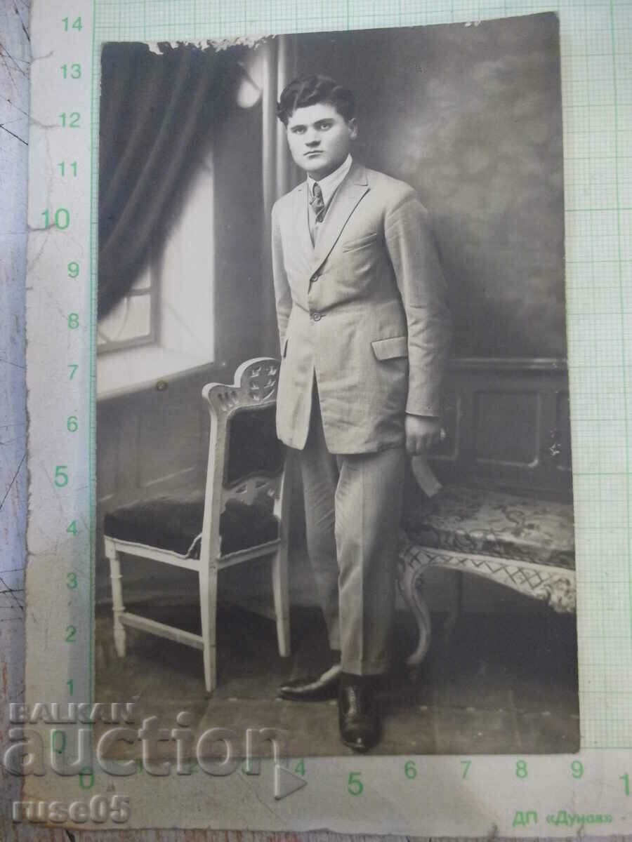 Old photo of a gentleman next to the chair