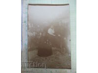 Old photo of two women and a man in front of the fence