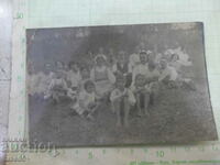 Old photo of a group sitting on the grass