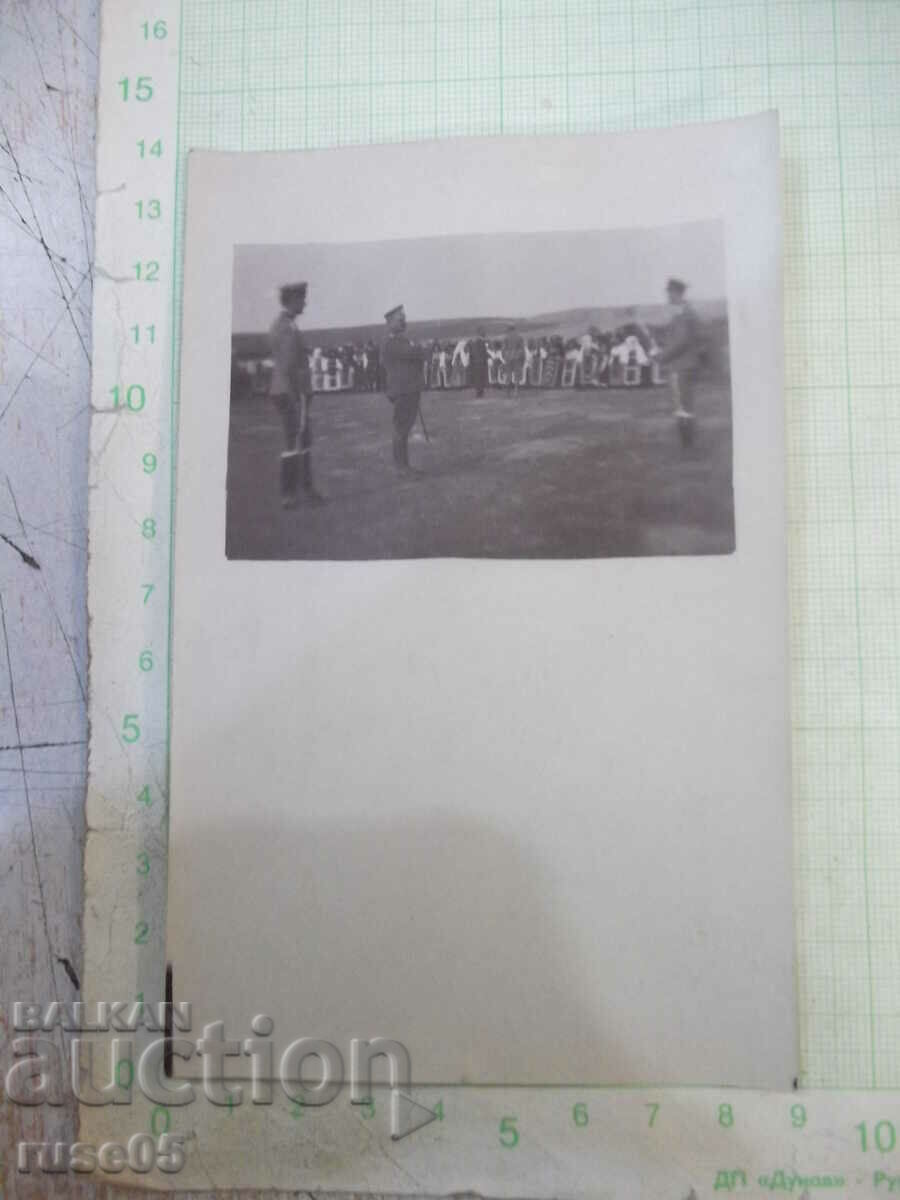 Old photo of dancing women in costumes in front of soldiers