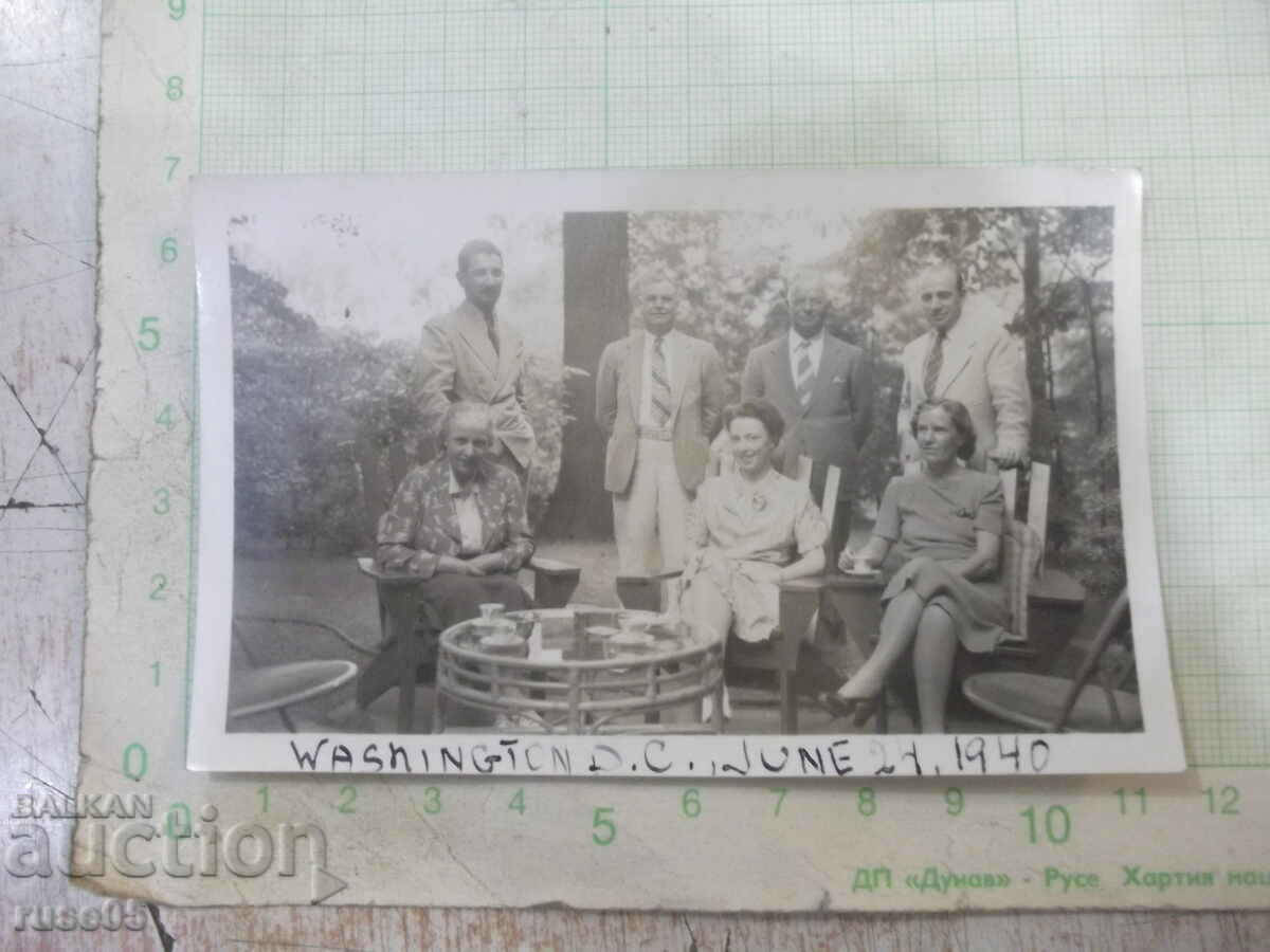 Old photo of three families at a table in the garden