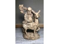 o statuie a zeului japonez Fukurokuju călare pe o căprioară