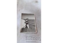 Photo Young girl next to a rock in the sea