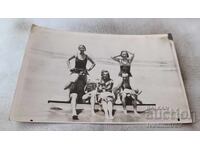 Photo Young men and women on a platform on the seashore