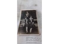 Photo Three young girls sitting on a park bench