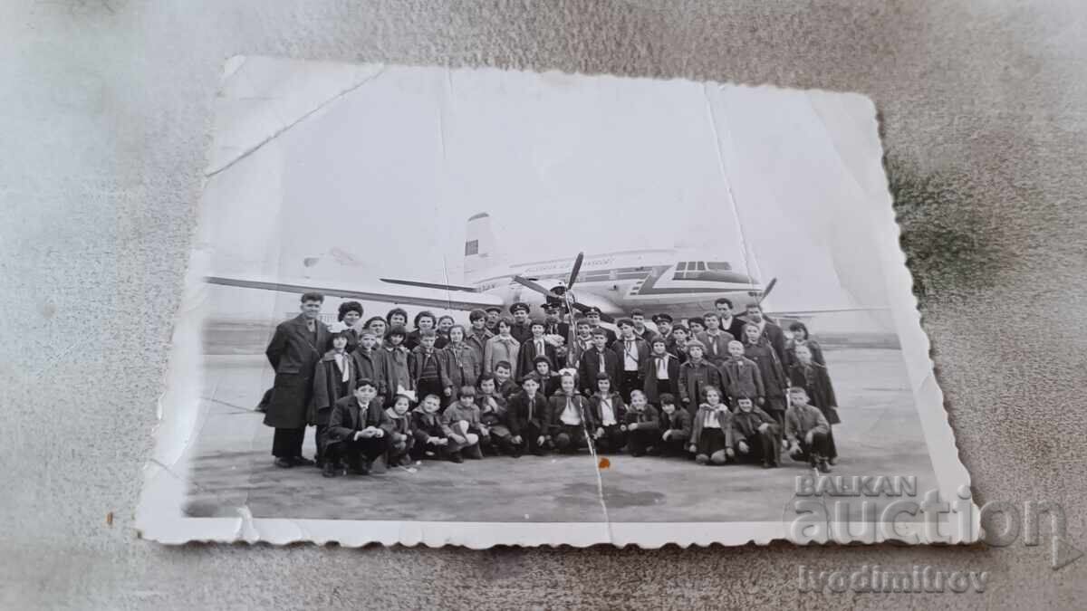 Photo Men women and children on the runway in front of a plane at BGA Balkan