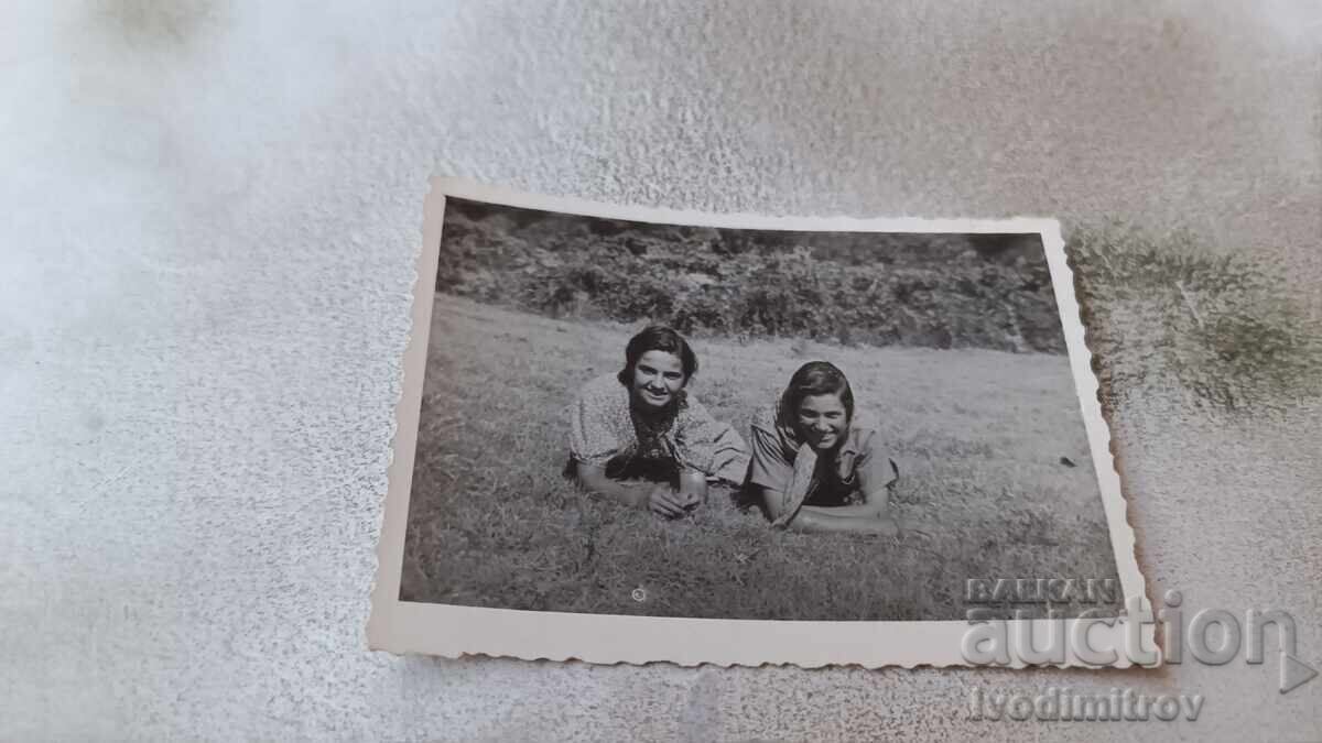 Photo Two young girls lying on the grass