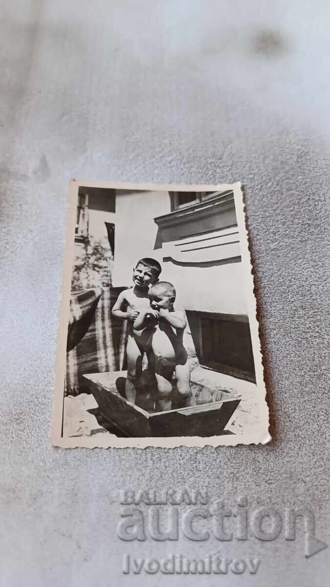 Photo Two boys in a bathing tub in the yard