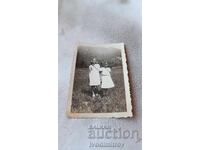 Photo Two girls with tricolor ribbons in the meadow