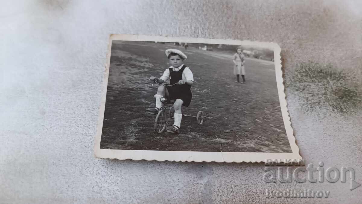 Fotografie Un băiețel cu o bicicletă retro pentru copii