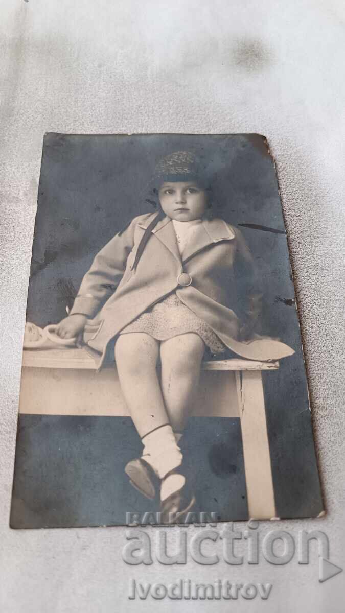 Photo Little girl sitting on a wooden bench