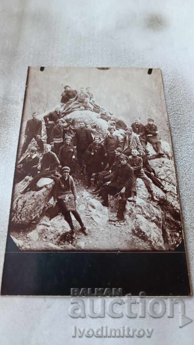Photo Young men and women on a rock in the mountains Photo Young men and women on a rock in the mountains