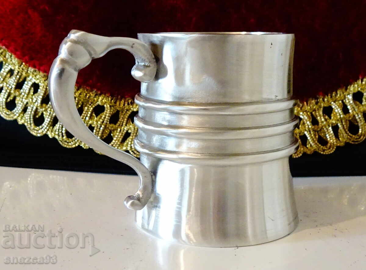 Livrarea O ceașcă de cositor cu un mâner spectaculos. Livrarea O ceașcă de cositor cu un mâner spectaculos.