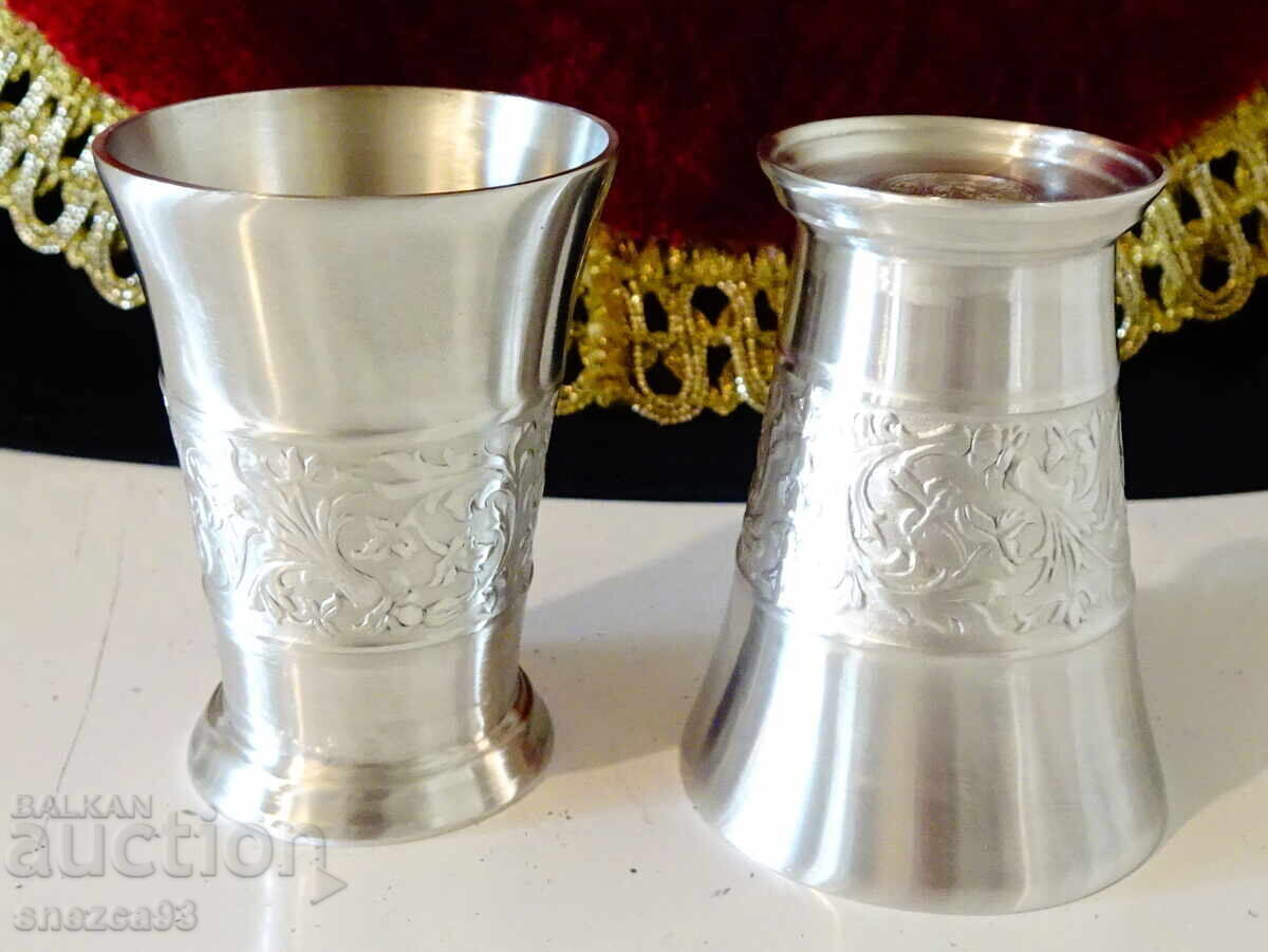 Tin cups with embossed floral motifs. Tin cups with embossed floral motifs.