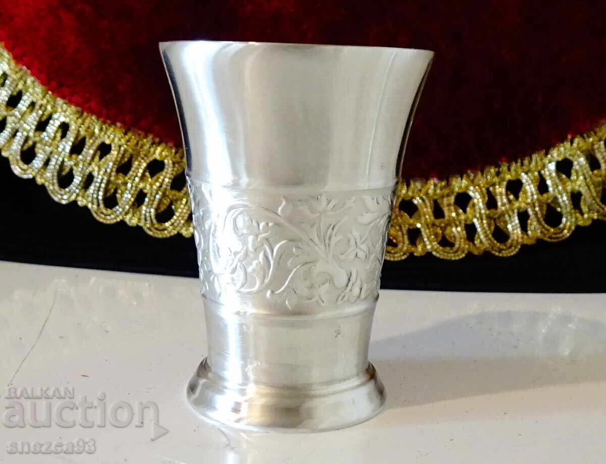 Pewter cup with embossed floral motifs. Pewter cup with embossed floral motifs.