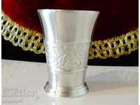 Pewter cup with embossed floral motifs.