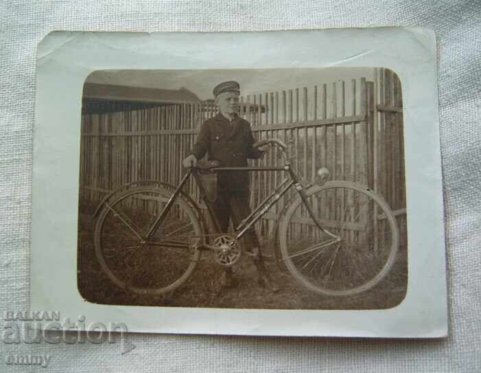 Fotografie veche a unui băiat cu o bicicletă, o bicicletă Fotografie veche a unui băiat cu o bicicletă, o bicicletă