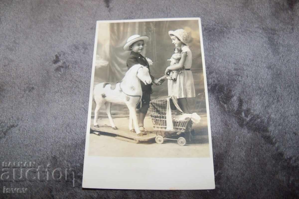 Delivery of Old postcard photo of children with toys Delivery of Old postcard photo of children with toys