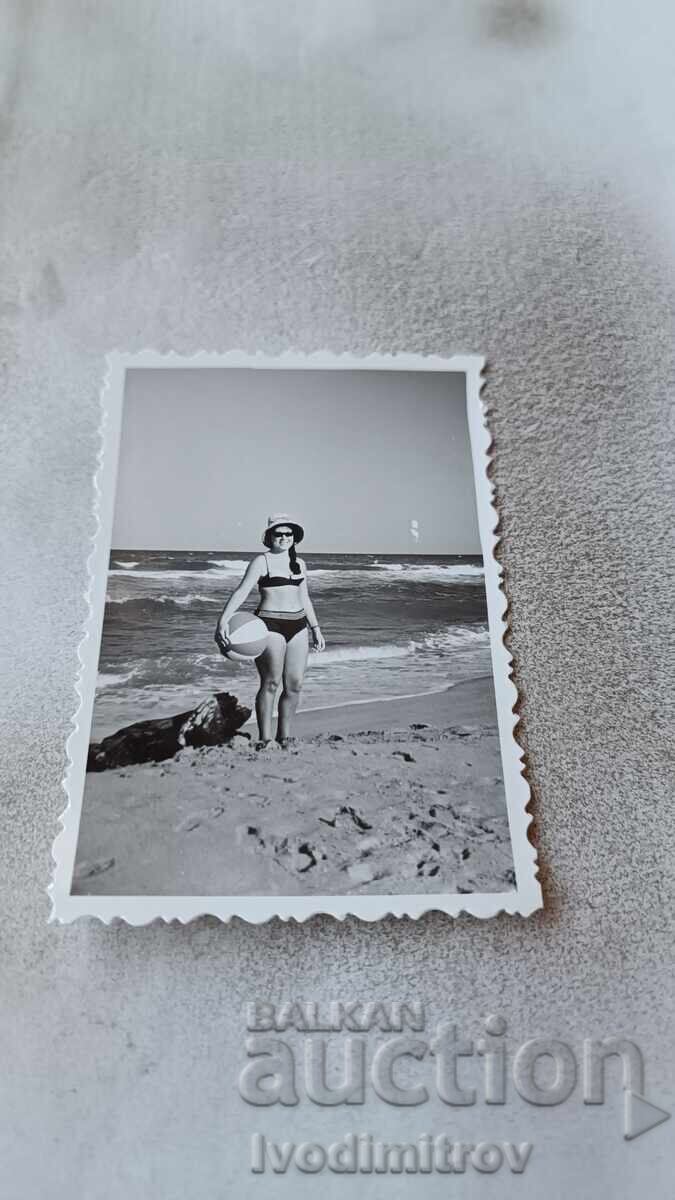 Φωτογραφία Νεαρή γυναίκα με μια μπάλα στην παραλία Φωτογραφία Νεαρή γυναίκα με μια μπάλα στην παραλία