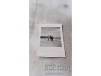 Photo Young man and two young girls on the seashore