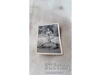 Photo Woman and two young girls lying on a stone in the sea