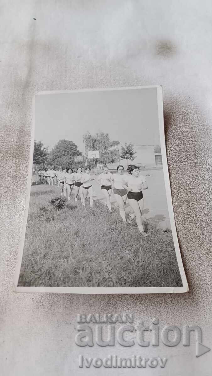 Foto: Fete aleargă într-o coloană una câte una Foto: Fete aleargă într-o coloană una câte una