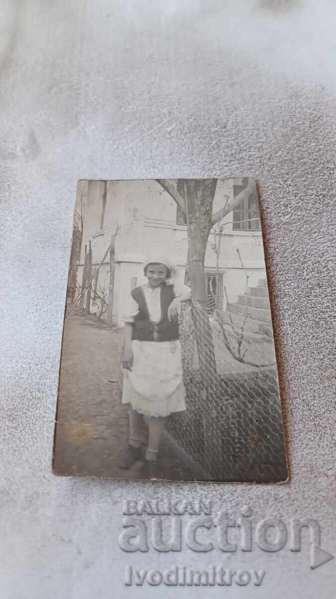 Photo Young girl in traditional clothing on the sidewalk Photo Young girl in traditional clothing on the sidewalk