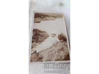 Photo Young girl in a white dress lying on a rock above the sea