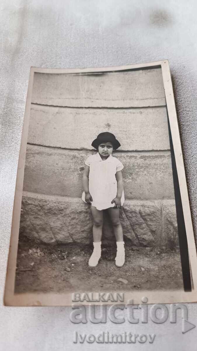 Photo Little girl next to a building Photo Little girl next to a building