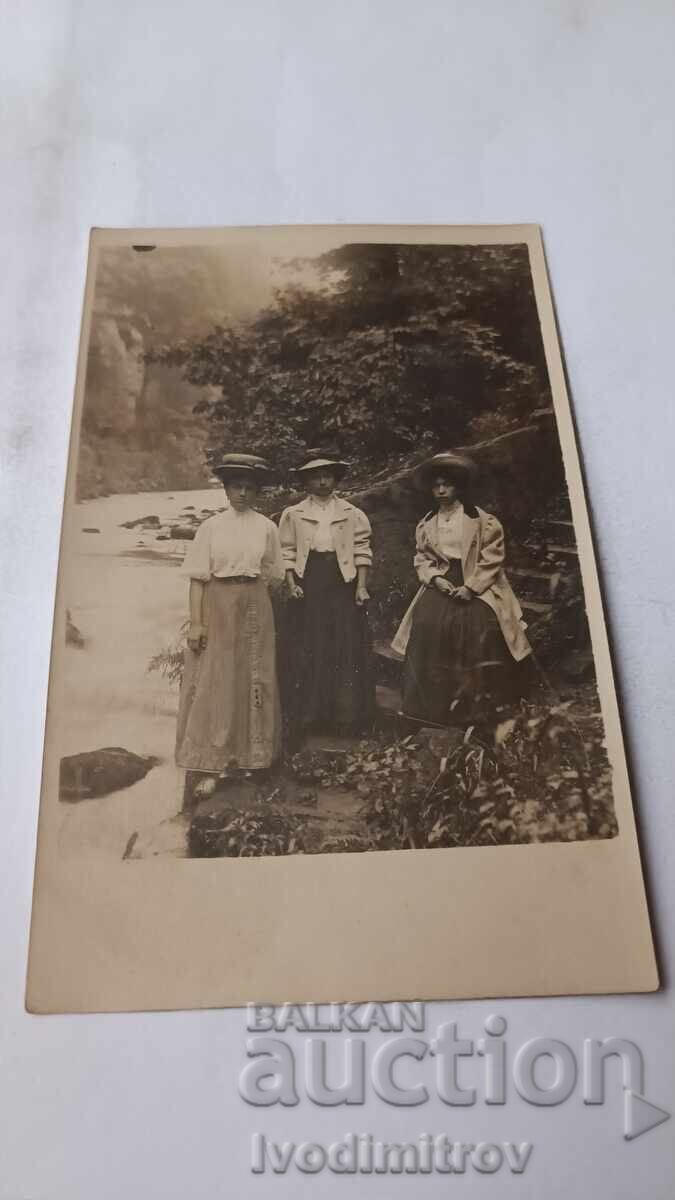 Φωτογραφία Τρεις νεαρές γυναίκες δίπλα σε ορμητικό ρέμα