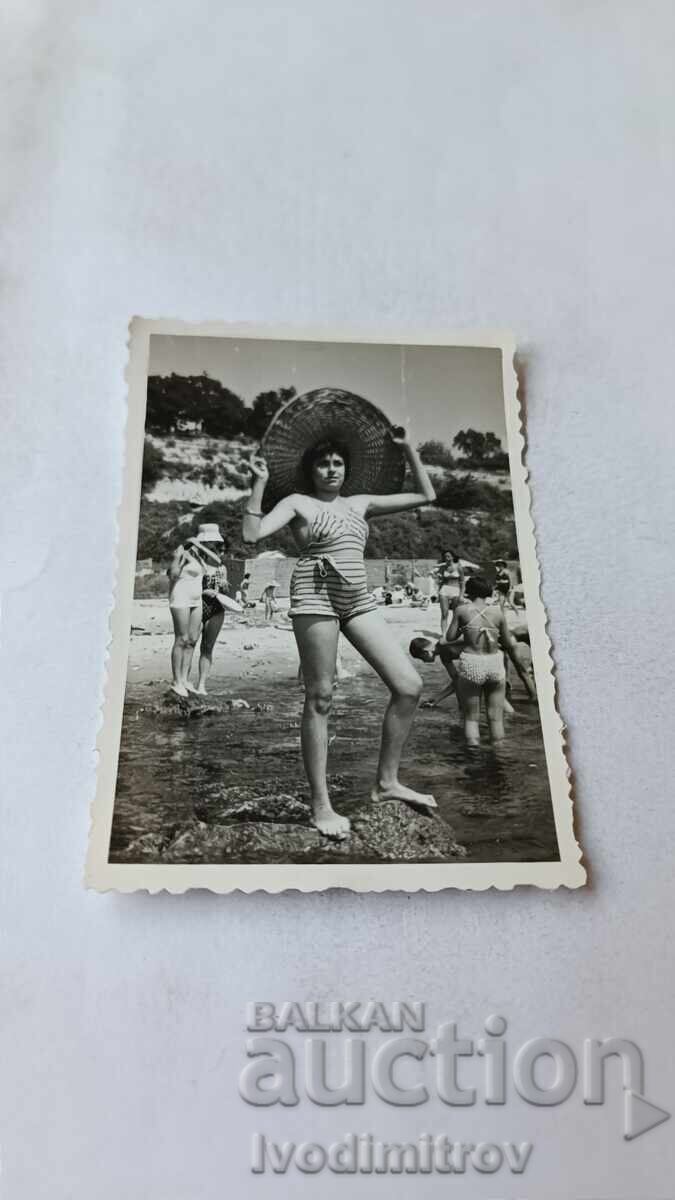 Снимка Млада жена на скала в морето