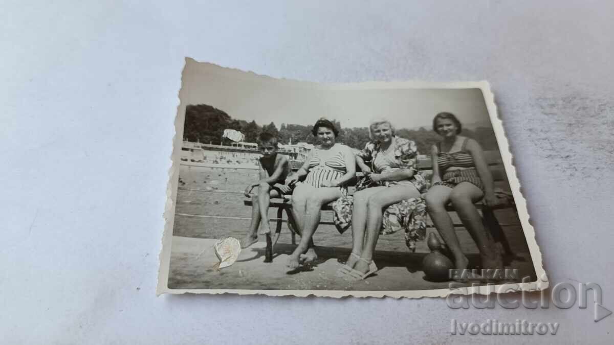 Снимка Три жени и момче седнали на пейка на пристана