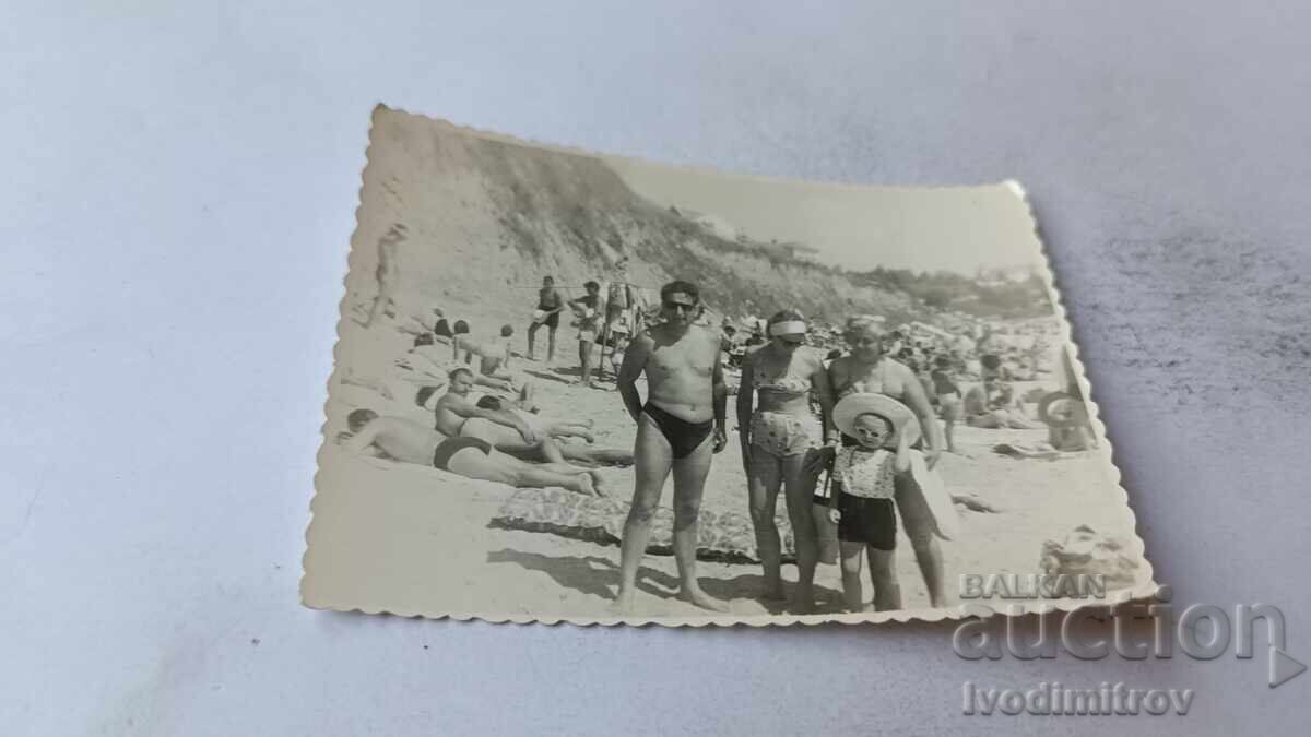 Fotografie cu un bărbat, două femei și un băiețel pe plajă