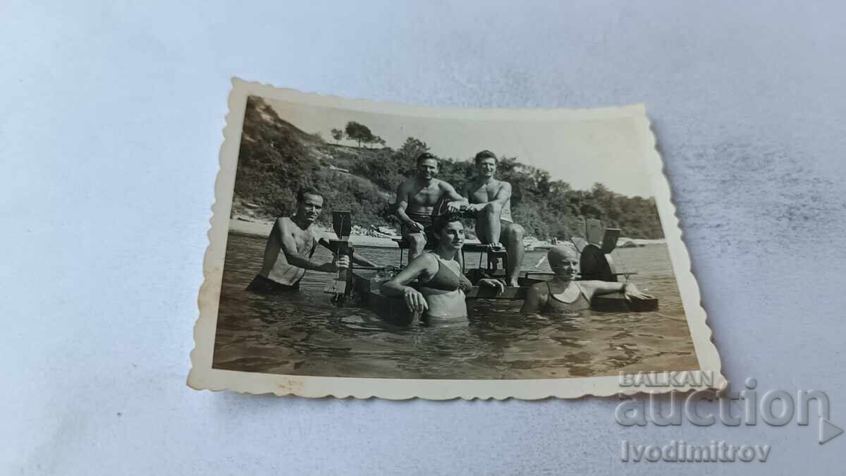 Photo of Young Men and Women with a Water Wheel in the Sea