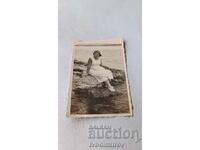 Fotografie: Femeie stând pe o stâncă lângă mare