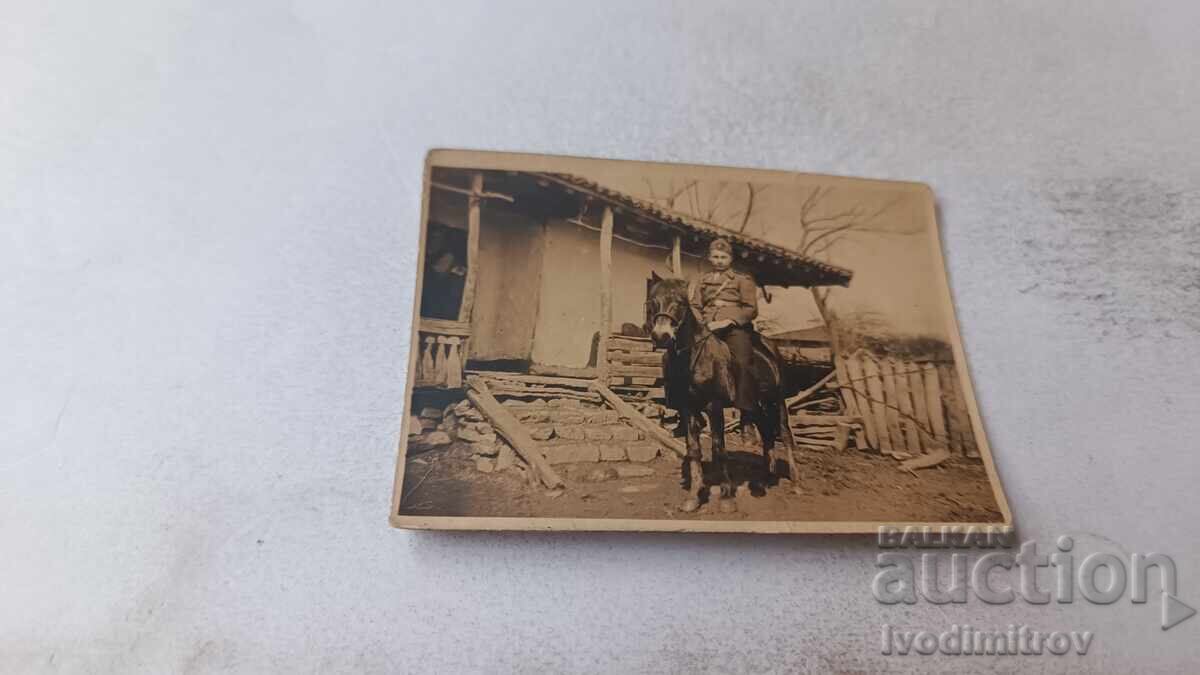 Photograph of an Officer on a Horse in the Yard of a Village House
