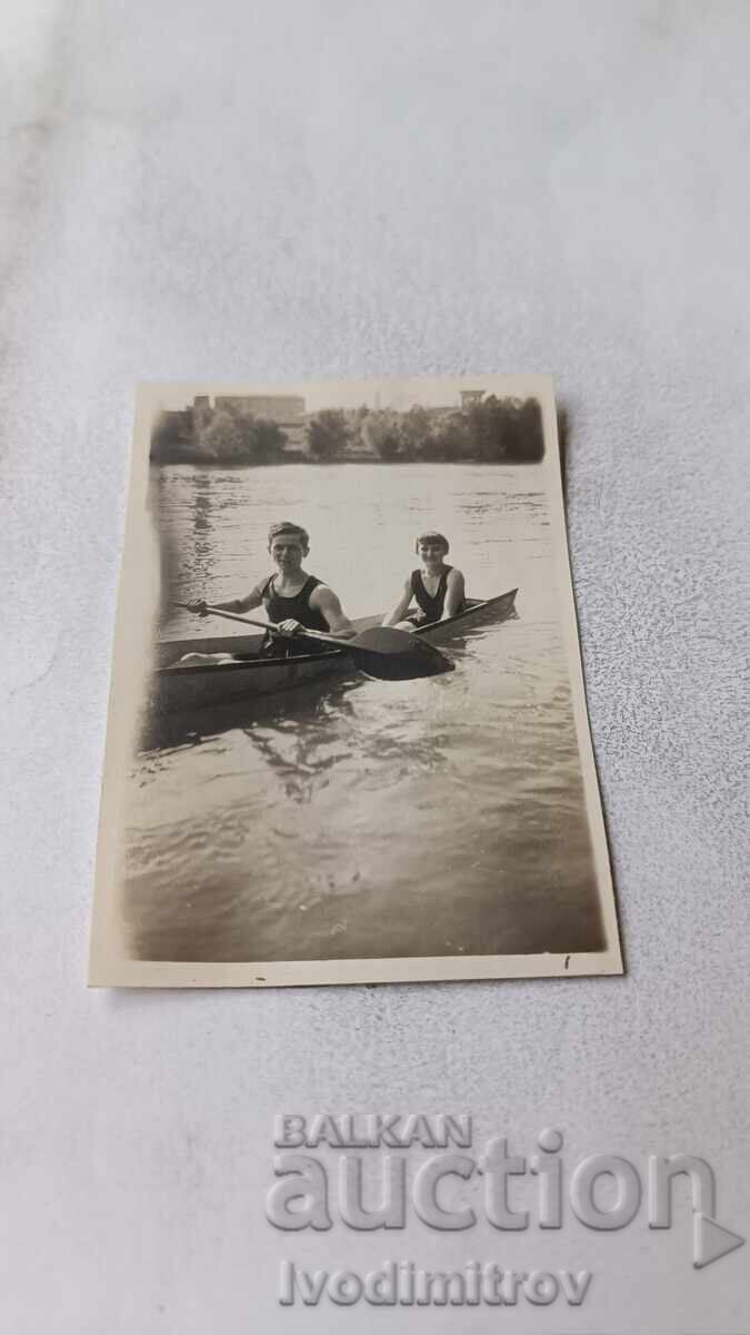 Fotografie Băiat și fată cu canoe pe râu Fotografie Băiat și fată cu canoe pe râu