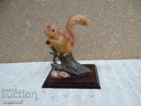 Figurine of a red squirrel on a wooden base