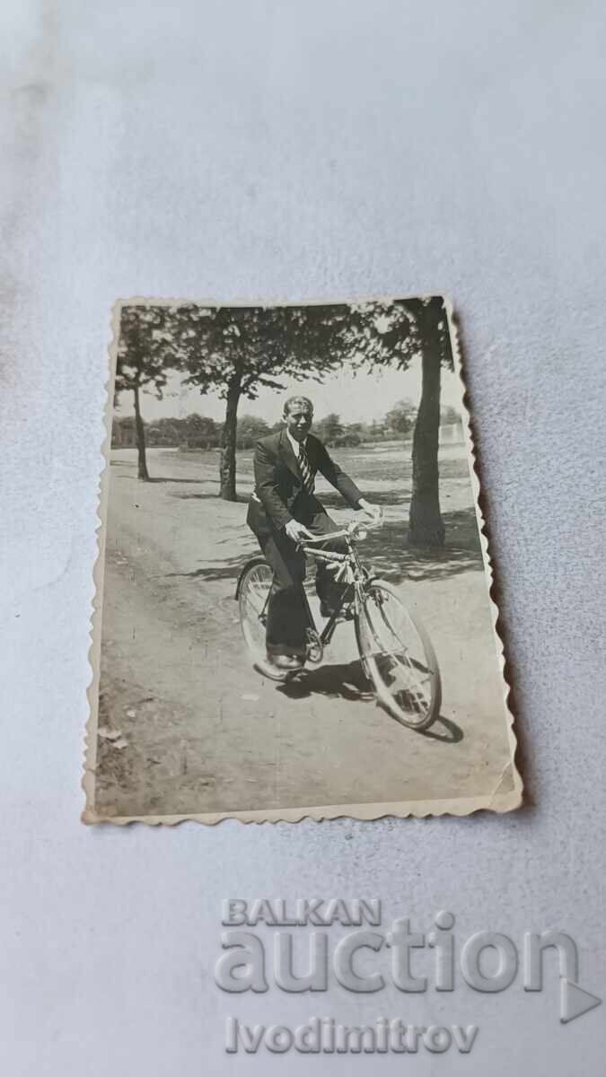 Photo of a man in a suit with a retro bicycle on the road Photo of a man in a suit with a retro bicycle on the road