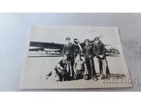 Fotografie cu cinci piloți în fața unui avion cu elice pe pistă