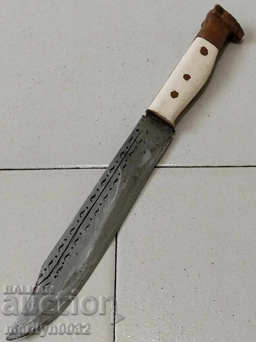 Old knife without a sheath with primitive engravings, dagger, fist