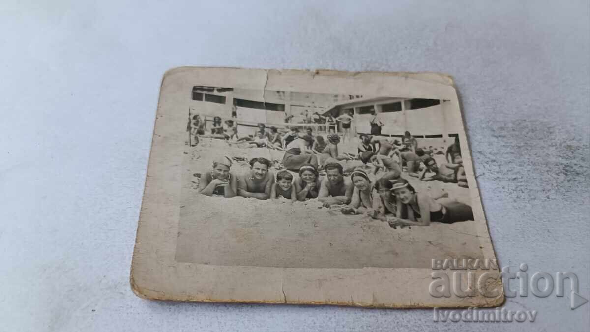 Φωτογραφία Άνδρες γυναίκες και αγόρι ξαπλωμένοι στην παραλία Φωτογραφία Άνδρες γυναίκες και αγόρι ξαπλωμένοι στην παραλία