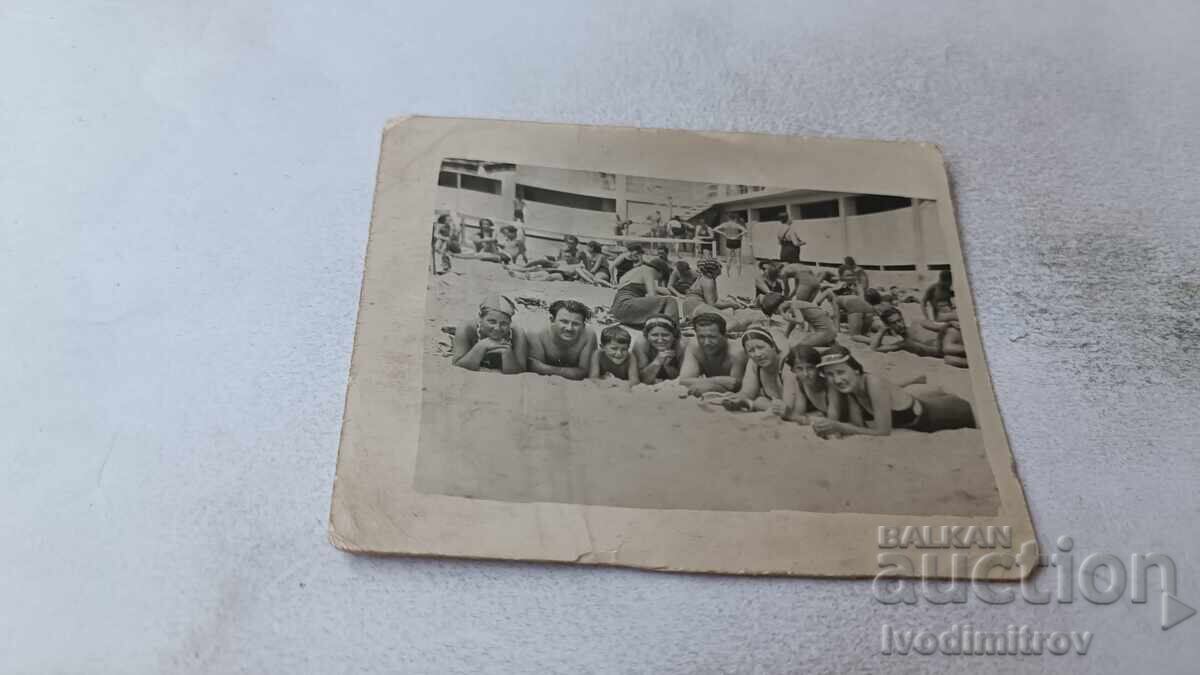 Φωτογραφία Άνδρες γυναίκες και αγόρι ξαπλωμένοι στην παραλία Φωτογραφία Άνδρες γυναίκες και αγόρι ξαπλωμένοι στην παραλία