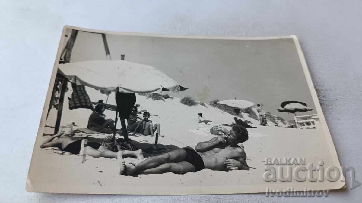 Fotografie Bărbat fumând țigară și întins pe plajă