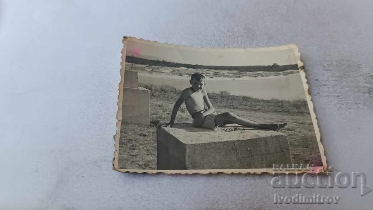 Снимка Момче седнало на бетонен блок