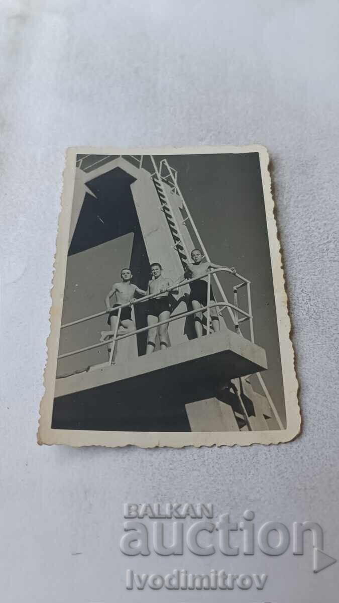 Φωτογραφία Τρία αγόρια σε πύργο πισίνας