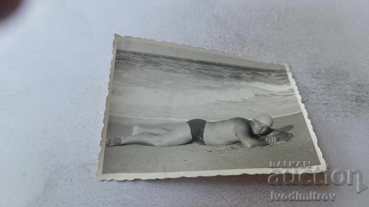 Снимка Мъж легнал на брега на морето Снимка Мъж легнал на брега на морето